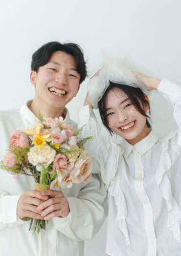 花束を持ち、満面の笑みのカップルの入籍フォト